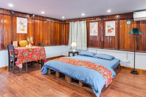a bedroom with two beds and a table in it at Hanoi Retro 80S Homestay in Hanoi