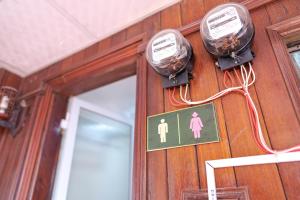 a bathroom with a sign on a wooden wall with a door at Hanoi Retro 80S Homestay in Hanoi