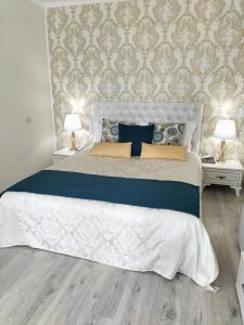 a bedroom with a large white bed with two night stands at Park Apartments in Dnipro