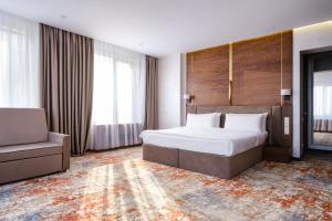 1 dormitorio con 1 cama, 1 sofá, 1 cama y 1 silla en Grand Mildom Hotel en Almaty
