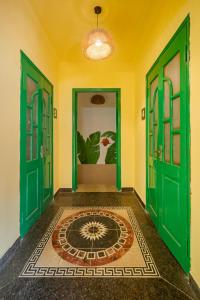 a hallway with green doors and a rug on the floor at Hanoi Retro 80S Homestay in Hanoi