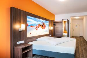 1 dormitorio con 1 cama con una película en la pared en Schroeders Wein-Style-Hotel en Tréveris