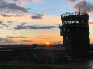 una torre de control del aeropuerto con la puesta de sol en el fondo en Lancaster en Boston
