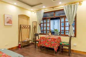 a dining room with a table and chairs and a window at Hanoi Retro 80S Homestay in Hanoi