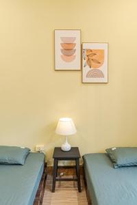 a room with two beds and a table with a lamp at Hanoi Retro 80S Homestay in Hanoi