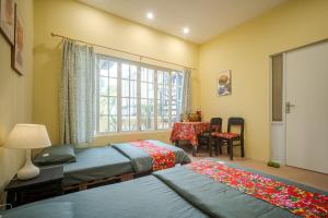 a bedroom with two beds and a window at Hanoi Retro 80S Homestay in Hanoi