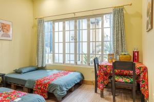 a room with two twin beds and a window at Hanoi Retro 80S Homestay in Hanoi