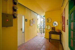 a hallway with yellow walls and a table in a room at Hanoi Retro 80S Homestay in Hanoi