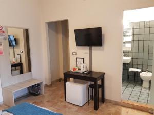 a room with a table and a tv on a wall at B&B Monté in Montesilvano
