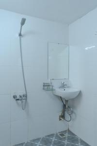 bagno bianco con lavandino e specchio di Hanoi Retro 80S Homestay a Hanoi