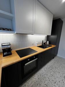 eine Küche mit einer Arbeitsfläche aus Holz und einem Waschbecken in der Unterkunft OhMyHome - Platynowa in Warschau
