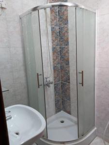 a shower with a glass door next to a sink at Basma Plaza in Abha