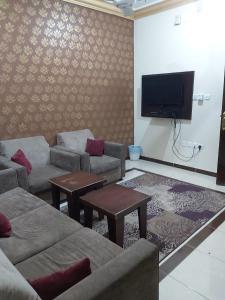 a living room with couches and a flat screen tv at Basma Plaza in Abha