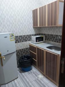 a small kitchen with a sink and a refrigerator at Basma Plaza in Abha