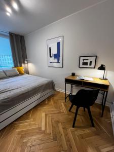 a bedroom with a bed and a desk with a chair at OhMyHome - Platynowa in Warsaw