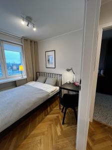 Schlafzimmer mit einem Bett, einem Schreibtisch und einem Fenster in der Unterkunft OhMyHome - Platynowa in Warschau
