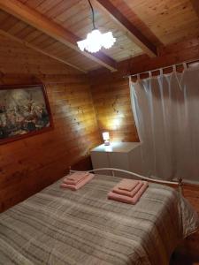 una camera con un letto in una cabina di legno di Chalet sa end my a Sellano