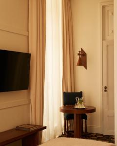 a room with a table and a television and a curtain at Château Voltaire in Paris