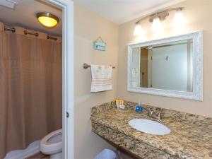 a bathroom with a sink and a toilet and a mirror at Laguna Reef #116 - The Heron Room in Rockport