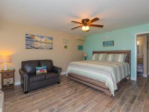 a bedroom with a bed and a chair at Laguna Reef #116 - The Heron Room in Rockport