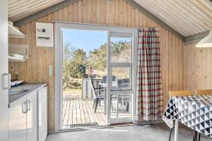 a kitchen with a sliding glass door leading to a patio at First Camp Råbjerg Mile - Skagen in Skagen