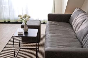 a living room with a couch and a table with flowers at Hotel AM MEER & Spa in Binz