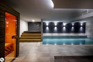 uma piscina num quarto com escadas em Panoráma Birtok - Wellness Panzió, Konferencia és Rendezvényközpont em Győrújbarát