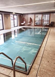 a swimming pool with blue water in a building at Apartmenthotel Oberstdorf in Oberstdorf