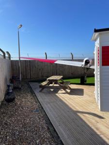 a wooden deck with a picnic table next to the ocean at Jetstream in Boston