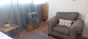 uma sala de estar com uma cadeira e uma televisão em Comfortable double room em Londres