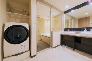 a washing machine in a bathroom with a sink and a tub at stayme THE HOTEL Ueno in Tokyo