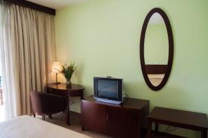 a hotel room with a television and a mirror at Gorillas Volcanoes Hotel in Ruhengeri