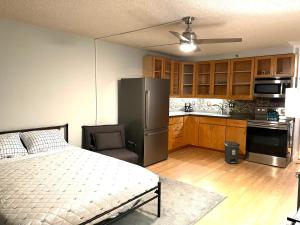a bedroom with a bed and a kitchen with a refrigerator at Marine Surf in Honolulu