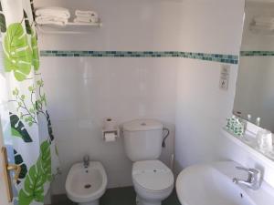 Baño blanco con aseo y lavamanos en Hotel Clibomar Jamaica, en Gandía