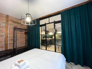 トルンにあるCentral Old Town Apartments - Green Loft and BelleViewのベッドと大きな窓のある寝室