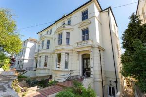 a white house with a staircase in front of it at Luxurious Victorian, a few minutes from the beach in Hollington