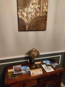 una mesa con una lámpara y libros en ella en Brads Pad -Ballymena Central- en Ballymena