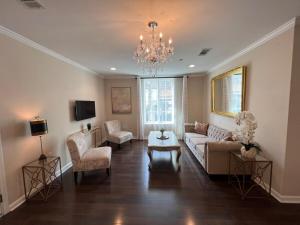 a living room with a couch and chairs and a chandelier at Tise Plaza Condos in New Orleans