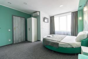 1 dormitorio con cama y pared verde en Art Hotel Palma, en Leópolis