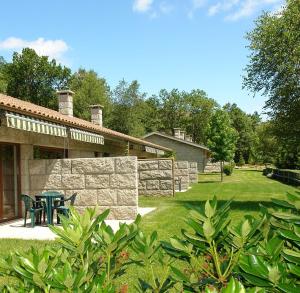 un patio con una mesa y una pared de piedra en Bungalows - Serra do Gerês, en Campo do Gerês