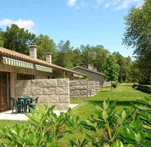 un cortile con un tavolo e un muro di pietra di Bungalows - Serra do Gerês a Campo do Gerês