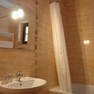 a bathroom with a sink and a mirror and a tub at Bungalows - Serra do Gerês in Campo do Gerês