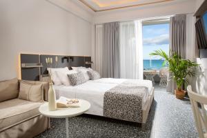 Habitación de hotel con cama y sofá en Pearl SeaBreeze Suites en Rethymno