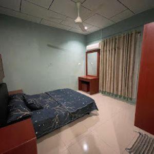 ein Schlafzimmer mit einem Bett in der Ecke eines Zimmers in der Unterkunft Alyaa Homestay in Gua Musang