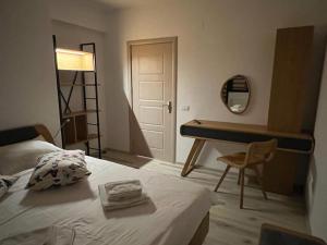a bedroom with a bed and a desk and a table at Coca Apart Mountain View in Sinaia