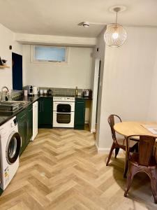 a kitchen with green cabinets and a table and a stove at 'Downtown' @ Terracotta Court in Bradford on Avon