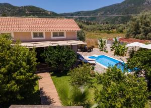 a villa with a swimming pool and mountains in the background at Villa Rigilis in Nydri