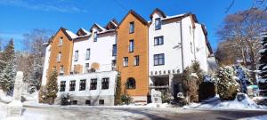 un gran edificio con nieve en el suelo en Boutique Eco Hotel Sasanka, en Szklarska Poręba