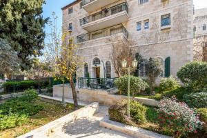 un edificio con un jardín delante de él en Nina Luxury Apartment en Jerusalem