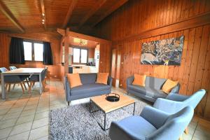 a living room with couches and a table and a kitchen at La Tanière in Noiseux